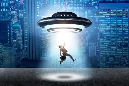 Flying saucer abducting young businessmanの写真素材