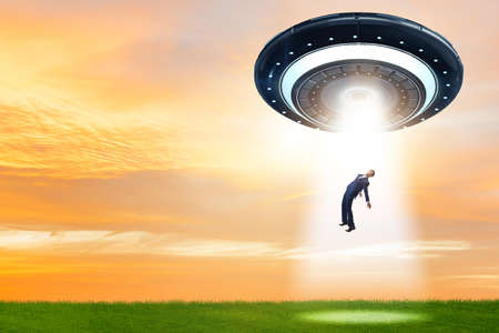 Flying saucer abducting young businessmanの写真素材