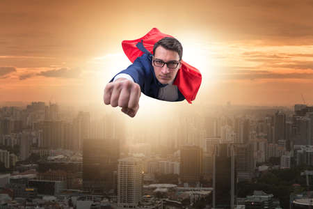 Superhero businessman flying over the cityの写真素材