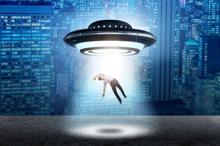 Flying saucer abducting young businessmanの写真素材