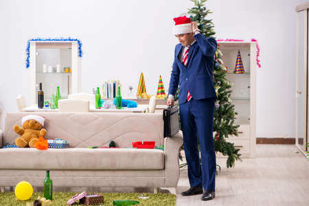 Young handsome employee celebrating Christmas at workplaceの写真素材