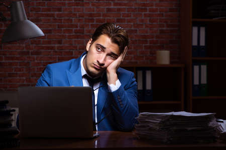 Young businessman working in the office at nightの写真素材