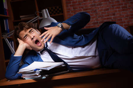 Young businessman working in the office at nightの写真素材