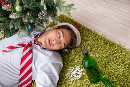 Young handsome employee celebrating Christmas at workplaceの写真素材