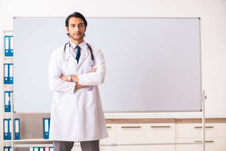 Young doctor in front of whiteboardの写真素材