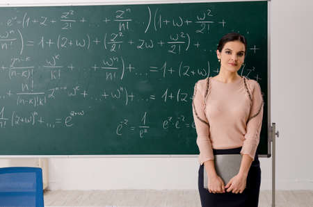 Female teacher standing in front of chalkboard