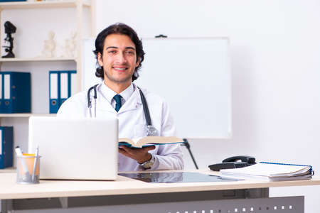 Young handsome doctor working in clinicの写真素材