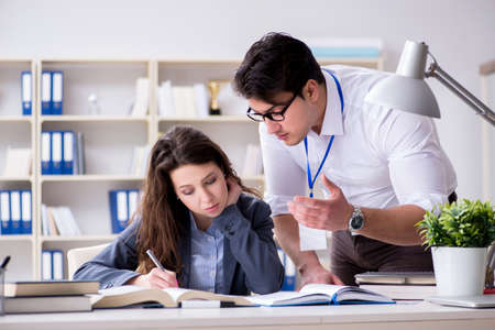 Teacher explaining to student at lectureの写真素材