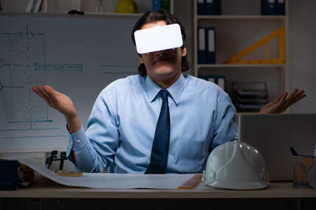 Young male architect working night at office