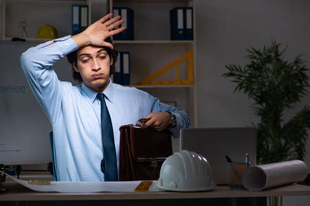 Young male architect working night at office