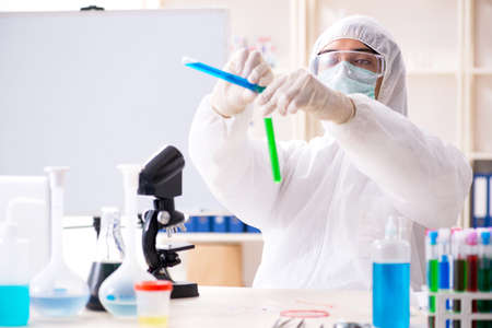 Young handsome chemist working in the lab