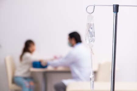 Young male foctor and female patient in blood transfusion conceptの写真素材