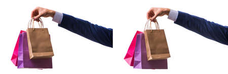 Hand holding shopping bags with christmas shopping on white backの写真素材