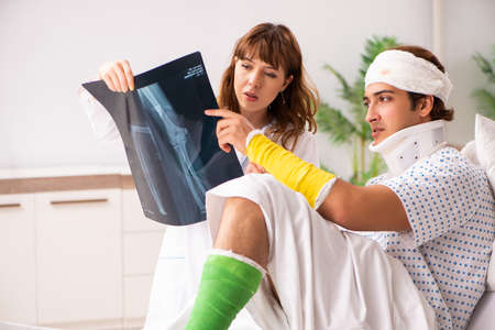 Young doctor examining injured patient