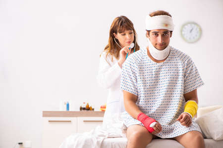 Young doctor examining injured patientの写真素材