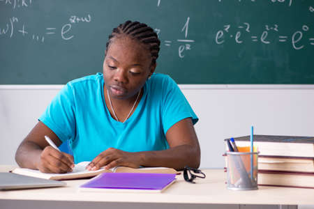 Black female student in front of chalkboardの写真素材