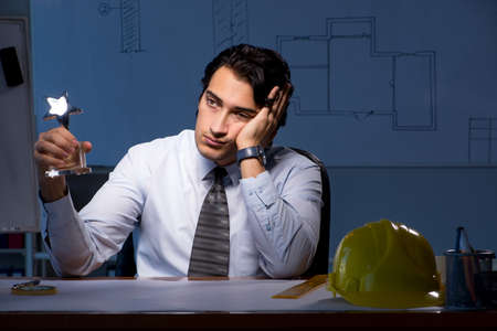 Young construction architect working on project at nightの写真素材