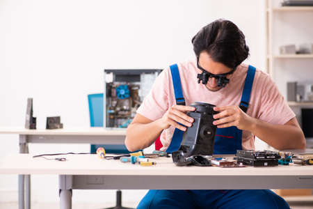 Young male contractor repairing computerの写真素材