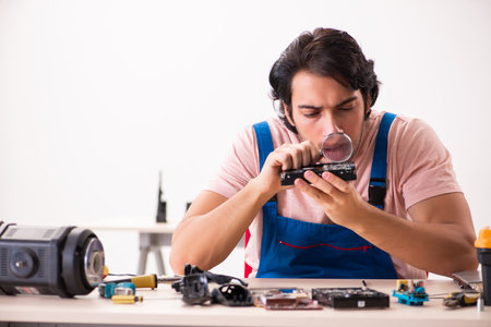 Young male contractor repairing computerの写真素材