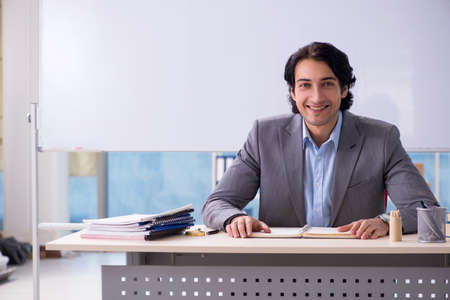 Young handsome teacher in front of whiteboardの写真素材