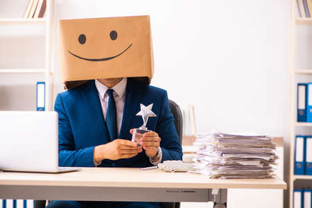 Happy man employee with box instead of his headの写真素材