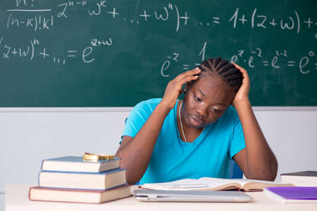 Black female student in front of chalkboardの写真素材