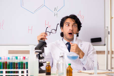 Young funny chemist in front of white boardの写真素材