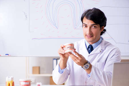 Young handsome dentist in front of the whiteboard