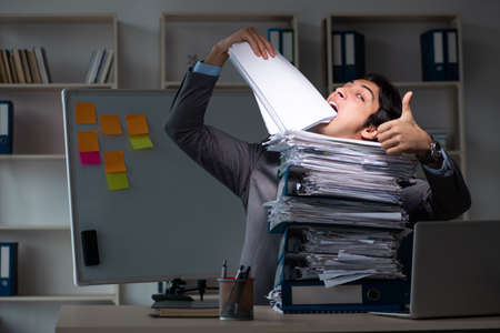 Young male employee working late at office
