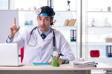 Young handsome doctor otolaryngologist in front of whiteboardの写真素材