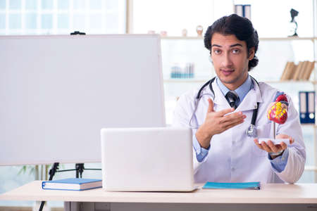 Young handsome doctor cardiologist in front of whiteboardの写真素材