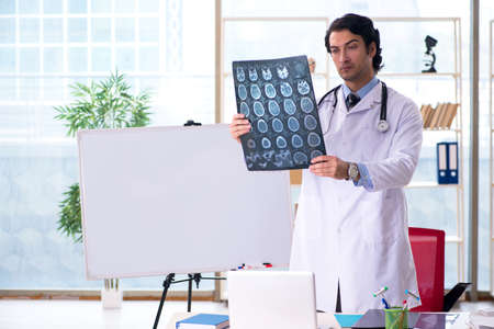 Young handsome male radiologist in front of whiteboard
