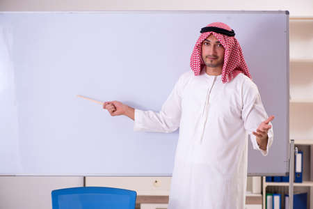 Arab teacher in front of whiteboardの写真素材