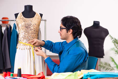 Young male tailor working at workshop