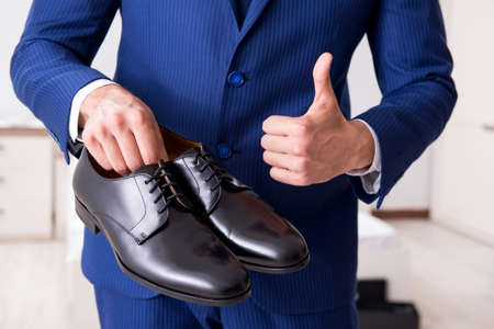 Young handsome businessman choosing shoes at homeの写真素材