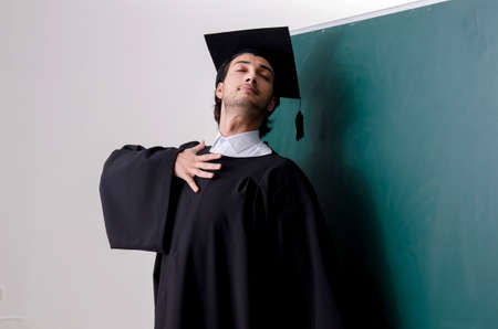 Graduate student in front of green boardの写真素材