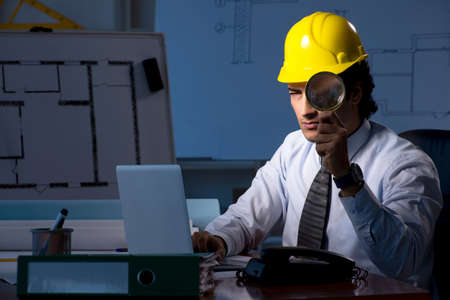 Young construction architect working on project at night