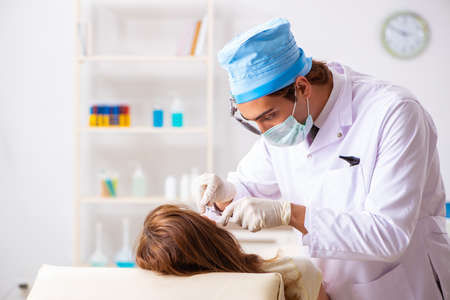 Young woman visting male doctor otolaryngologistの写真素材