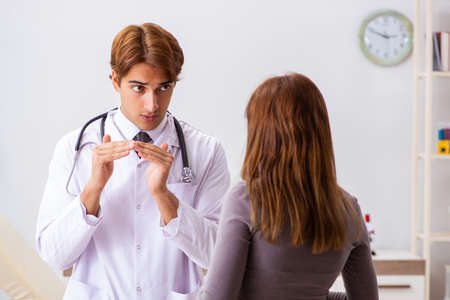 Deaf-mute female patient visiting young male doctorの写真素材