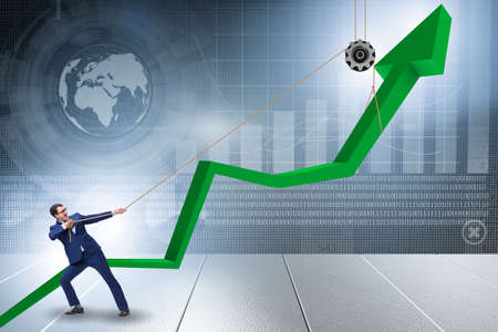 Businessman supporting economic growth by pulling ropeの写真素材