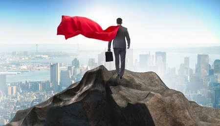 Superhero businessman on top of mountainの写真素材