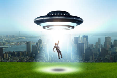 Flying saucer abducting young businessmanの素材 [FY310117492851]