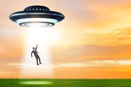 Flying saucer abducting young businessmanの写真素材