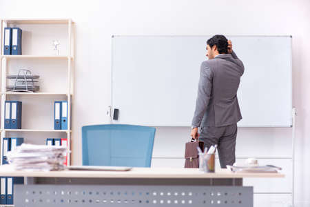 Young handsome businessman standing in front of whiteboardの写真素材