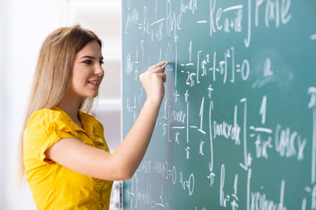 Young female student in front of the chalkboard