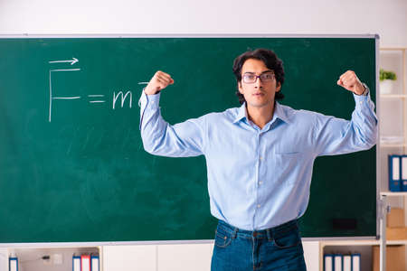 Young male physic standing in front of the green boardの写真素材