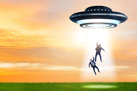Flying saucer abducting young businessmanの写真素材