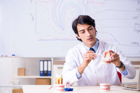 Young handsome dentist in front of the whiteboard