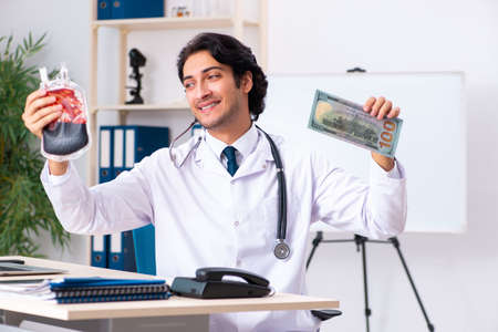 Young handsome doctor in blood transfusion conceptの写真素材