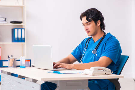 Young handsome doctor working at the clinicの写真素材